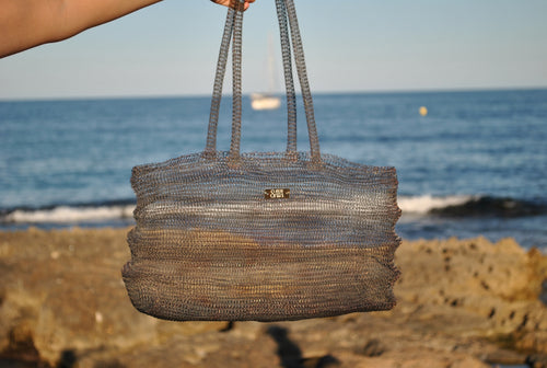 Bolso Ombak negro artesanal de SAYA  frente al mar hecho a mano.