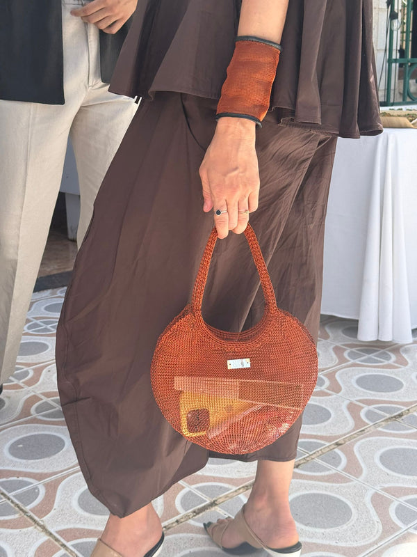 Chica con  Bolso Nusa rojo de crochet metálico tejido a mano